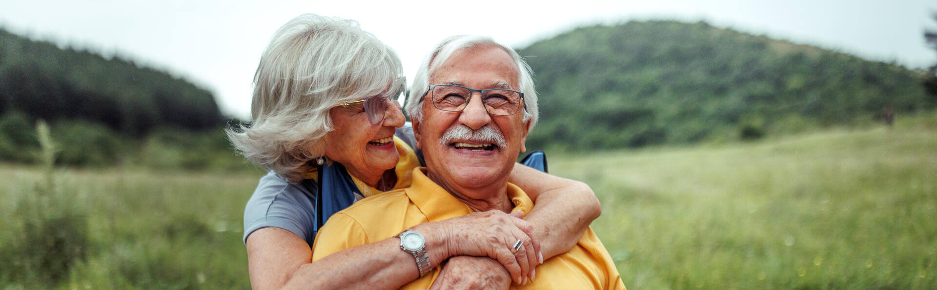 Affectionate senior couple bonding while camping together at forest