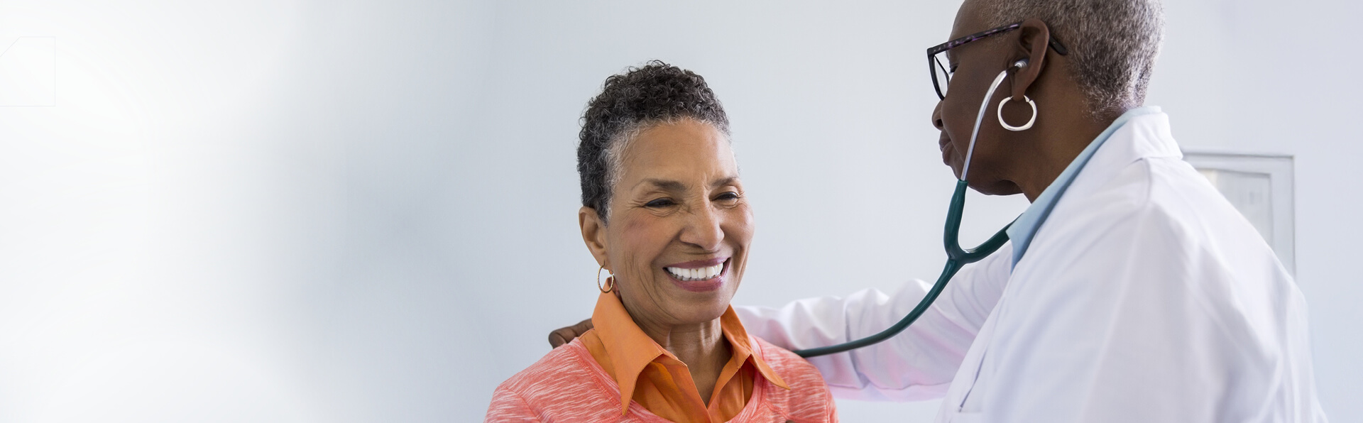 A provider using their stethoscope to listen to a patient.